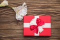 Real box with white and red bow and ribbon top view on Valentine`s day isolated on wooden background. Flat lay. Copy space Royalty Free Stock Photo