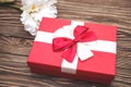 Real box with white and red bow and ribbon top view on Valentine`s day isolated on wooden background. Flat lay. Copy space Royalty Free Stock Photo