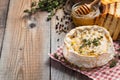 A real Camembert from France with thyme, honey and toasted bread on old wooden rustic table. Soft cheese on a wooden background wi Royalty Free Stock Photo