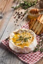 A real Camembert from France with thyme, honey and toasted bread on old wooden rustic table. Soft cheese on a wooden background. T Royalty Free Stock Photo