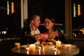 Real candlelight dinner for two, valentine's day date, couple having dinner man giving a woman a gift, romantic family Royalty Free Stock Photo