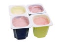 Real cheap nonfat cherry and strawberry yogurt in blue and green open plastic cups isolated macro