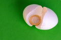 The real coin of one euro inside a broken egg. Eggshell and money on green background. The concept of wealth for Easter. Copy Royalty Free Stock Photo