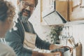 Real couple cooking together at home in the kitchen. One man smile to a woman and using pots preparing lunch. Husband and wife Royalty Free Stock Photo