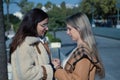 Real couple of young women, holding hands, looking at each other and talking in affectionate attitude. Concept lgtbiq+, lesbians, Royalty Free Stock Photo