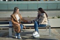 Real couple of young women, holding hands, sitting on a bench, talking in a loving attitude. Concept lgtbiq+, lesbians, in love, Royalty Free Stock Photo