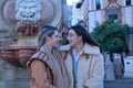 Real couple of young women, sitting in a fountain while laughing and talking. Concept lgtbiq+, lesbians, in love, inclusion Royalty Free Stock Photo