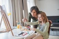 Girl looking at the picture while drawing near her happy grandmother Royalty Free Stock Photo