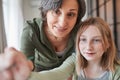 Happy child holding brush and painting while her granny helping to her Royalty Free Stock Photo