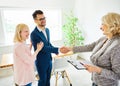 young couple shaking hands deal contract real estate investment business agreement agent handshake signing Royalty Free Stock Photo