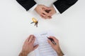 Real Estate Agent With Customer Signing Contract At Desk