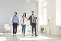 Real estate agent giving a young couple a tour around a spacious house or apartment Royalty Free Stock Photo