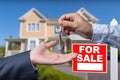 Real Estate Agent Handing Over the House Keys in Front of a Beautiful New Home and For Sale Real Estate Sign. Royalty Free Stock Photo