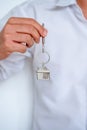 Real estate agent handing over house keys, Men hand holding key with house shaped keychain, Close up focus Royalty Free Stock Photo
