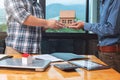 Real estate agent handing over a house model with his client after sealing deal