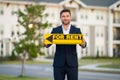 Real estate agent hold house rent sign. Real estate renting property. Rent new home. Handsome real estate agent in suit Royalty Free Stock Photo