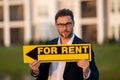 Real estate agent hold house rent sign. Real estate renting property. Rent new home. Handsome real estate agent in suit Royalty Free Stock Photo