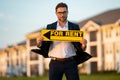 Real estate agent hold house rent sign. Real estate renting property. Rent new home. Handsome real estate agent in suit Royalty Free Stock Photo