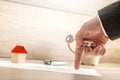 Real estate agent holding house key while showing with his finger where to sign a contract of house sale Royalty Free Stock Photo