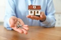 Real estate agent holding house model and keys at table, closeup Royalty Free Stock Photo