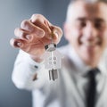 Real estate agent holding out house keys Royalty Free Stock Photo