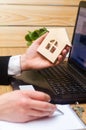 Real estate agent holds a house model, signs fills documents si Royalty Free Stock Photo