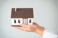 Real estate agent with house model on light background, closeup Royalty Free Stock Photo