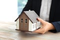 Real estate agent with house model sitting at wooden table, closeup Royalty Free Stock Photo