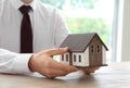 Real estate agent with house model at wooden table. Mortgage concept Royalty Free Stock Photo