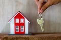 A real estate agent with a key. Red roof house. Offering home, property insurance, and housing safety concepts. Choosing a house Royalty Free Stock Photo