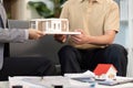 Real estate agent presenting model home to client in office Royalty Free Stock Photo