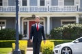 Real estate. Agent ready to sell home. Businessman standing outside a modern house. Royalty Free Stock Photo