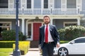 Real estate. Agent ready to sell home. Businessman standing outside a modern house. Dream home. Royalty Free Stock Photo