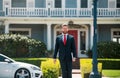 Real estate. Agent ready to sell home. Businessman standing outside a modern house. Royalty Free Stock Photo