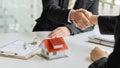 Real estate agent shakes hands with client after signing home purchase agreement after Finan has passed. Royalty Free Stock Photo