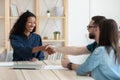 Real estate agent shaking hands with happy young couple. Royalty Free Stock Photo