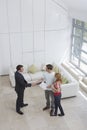 Real Estate Agent Shaking Hands With Man By Woman In New Home Royalty Free Stock Photo