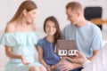 Real estate agent showing house model to family in his office Royalty Free Stock Photo