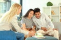 Real estate agent showing model of house to clients in her office Royalty Free Stock Photo