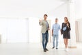Real estate agent showing new apartment to young couple. Royalty Free Stock Photo