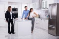 Real Estate Agent Showing Refrigerator In House To A Couple Royalty Free Stock Photo