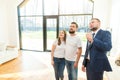 Real estate agent shows a young couple a new home. family buys housing Royalty Free Stock Photo