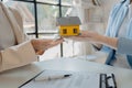 A real estate agent sits in her office, The salesperson is presenting what the home the customer is about to buy looks like, The Royalty Free Stock Photo