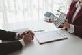 A real estate agent sits in her office, The salesperson is presenting what the home the customer is about to buy looks like, The Royalty Free Stock Photo