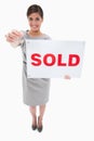 Real estate agent with sold sign handing over key Royalty Free Stock Photo