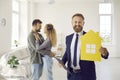 Real estate agent standing in new house that he has just sold to his happy clients Royalty Free Stock Photo