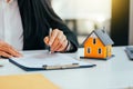 Real estate agent working sign agreement document contract for home loan insurance approving purchases for client with house model Royalty Free Stock Photo