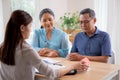 Real estate agent young asian woman talking with elderly couple and explaining mortgage or buying home insurance. Royalty Free Stock Photo