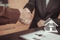 Real estate agents and customers shake hands to congratulate on signing a contract to buy a house with land and insurance