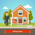 Real estate broker and house with for sale sign